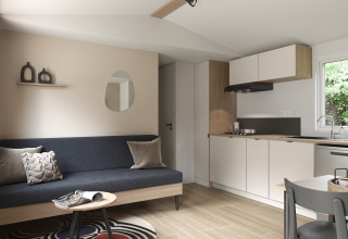 Modern living area and kitchenette inside COTTAGE Premium at Campsite Le Château, France, cozy and stylish décor.
