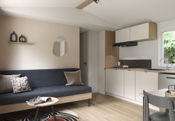 Moderne opholdsstue og tekøkken i COTTAGE Premium i Campsite Le Château, med stilfuldt interiør og lyse farver.