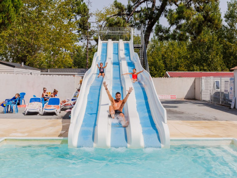 Familles s'amusant sur le grand toboggan aquatique à Flower Camping l'Escale du Perthuis, Pays de la Loire.