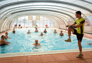 Istruttore guida lezione di acquagym in piscina coperta al Flower Camping l'Escale du Perthuis in Francia.