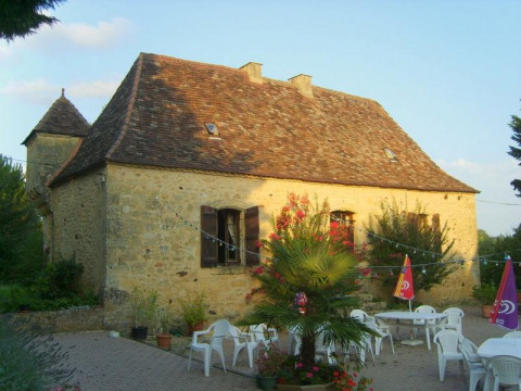 Casa in pietra al campeggio La Grande Véyière con terrazza, arredi da giardino e ombrelloni in Nouvelle-Aquitaine, Francia.