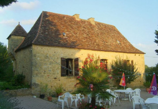 Casa in pietra al campeggio La Grande Véyière con terrazza, arredi da giardino e ombrelloni in Nouvelle-Aquitaine, Francia.