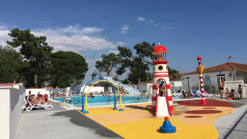 Piscine extérieure et aire de jeux avec phare au Flower Camping l'Escale du Perthuis en Pays de la Loire, France.
