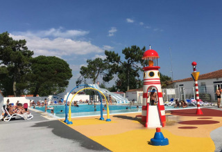 Piscine extérieure et aire de jeux avec phare au Flower Camping l'Escale du Perthuis en Pays de la Loire, France.