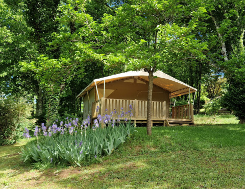 Una tenda glamping al campeggio La Grande Véyière in Nouvelle-Aquitaine, Francia, immersa nel verde.