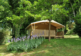 Una tenda glamping al campeggio La Grande Véyière in Nouvelle-Aquitaine, Francia, immersa nel verde.