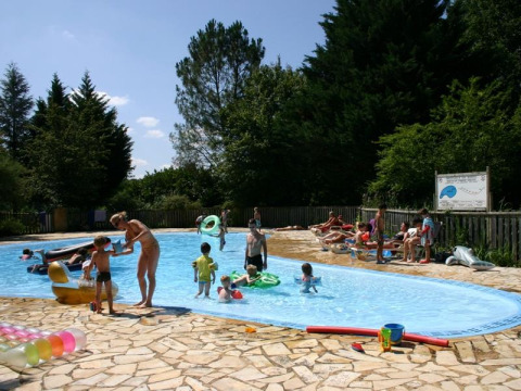 Bambini e adulti si divertono in piscina al campeggio La Grande Véyière in Nouvelle-Aquitaine, Francia.