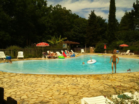 Piscina all'aperto del campeggio La Grande Véyière in Nouvelle-Aquitaine, Francia, con ospiti che nuotano.