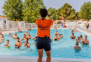 Instructor dirige una clase de aquagym para huéspedes en la piscina de Flower Camping l'Escale du Perthuis.