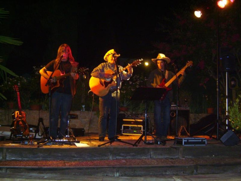 Band dal vivo si esibisce di notte sul palco al campeggio La Grande Véyière, parco vacanze in Nouvelle-Aquitaine, Francia.