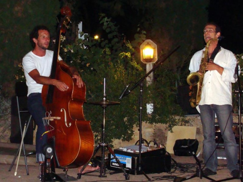 Due musicisti si esibiscono all'aperto di notte al campeggio La Grande Véyière in Nouvelle-Aquitaine, Francia.