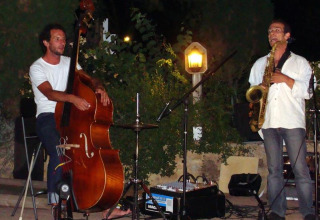 Due musicisti si esibiscono all'aperto di notte al campeggio La Grande Véyière in Nouvelle-Aquitaine, Francia.