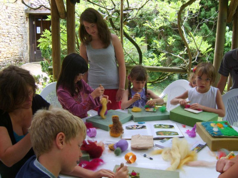 Bambini e adulti partecipano a un’attività artistica all’aperto al campeggio La Grande Véyière in Francia.
