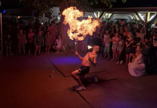 Un artista de fuego actúa ante una multitud en Flower Camping l'Escale du Perthuis, Pays de la Loire, Francia.