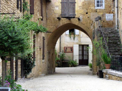 Vicolo in pietra con arco, scala e piante vicino a Molières in Nouvelle-Aquitaine, Francia.
