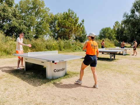 To personer spiller bordtennis udendørs på Flower Camping l'Escale du Perthuis i Pays de la Loire, Frankrig.