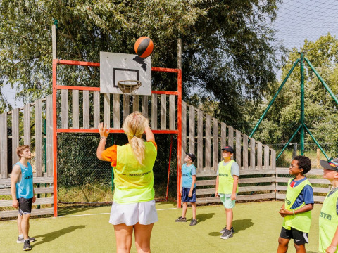 Kinder und Erwachsene spielen Basketball im Freien im Flower Camping l'Escale du Perthuis, Pays de la Loire, Frankreich.