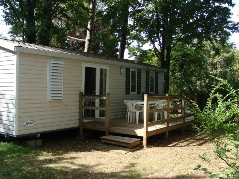 Mobile home Comfort en el camping La Grande Véyière en Francia, rodeado de árboles con terraza de madera.
