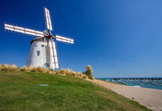 Molino de viento junto al puerto deportivo en Flower Camping l'Escale du Perthuis, Pays de la Loire, Francia.