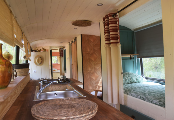 Innenraum der Lijn 3C gemütliche Schulbus-Lodge mit Küche, Doppelbett und viel Tageslicht.