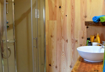 Modern wooden bathroom at the Chalet in Campsite Les 3 Cantons, France, featuring a glass shower cubicle.