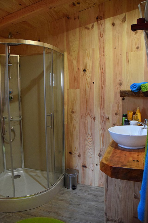 Bagno moderno in legno nello Chalet al Campeggio Les 3 Cantons in Francia con box doccia in vetro.