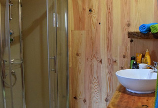 Bagno moderno in legno nello Chalet al Campeggio Les 3 Cantons in Francia con box doccia in vetro.
