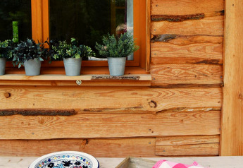 Outdoor table with bread, green mugs, plate, pink towel and potted plants at Chalet, Les 3 Cantons campsite in France.