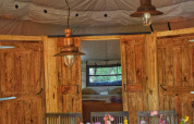 Interno della tenda safari Dôme al campeggio Les 3 Cantons in Francia con tavola apparecchiata e camera.