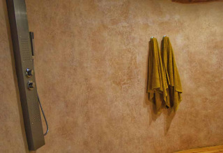 Doccia rustica con pannello moderno e soffitto in legno nella tenda safari 'Dôme' in Francia.