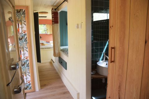 Interni del Lijn 3C, scuolabus accogliente con zona notte e bagno al Camping Les 3 Cantons, Francia.