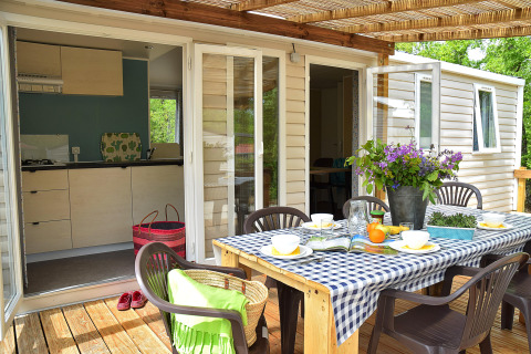 Espace repas extérieur sur la terrasse du Starcaravan Lavaurette au camping Les 3 Cantons, France.