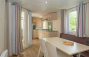 Intérieur moderne de mobil-home Midi Pyrénées au camping Les 3 Cantons, avec cuisine, salle à manger et fenêtres.