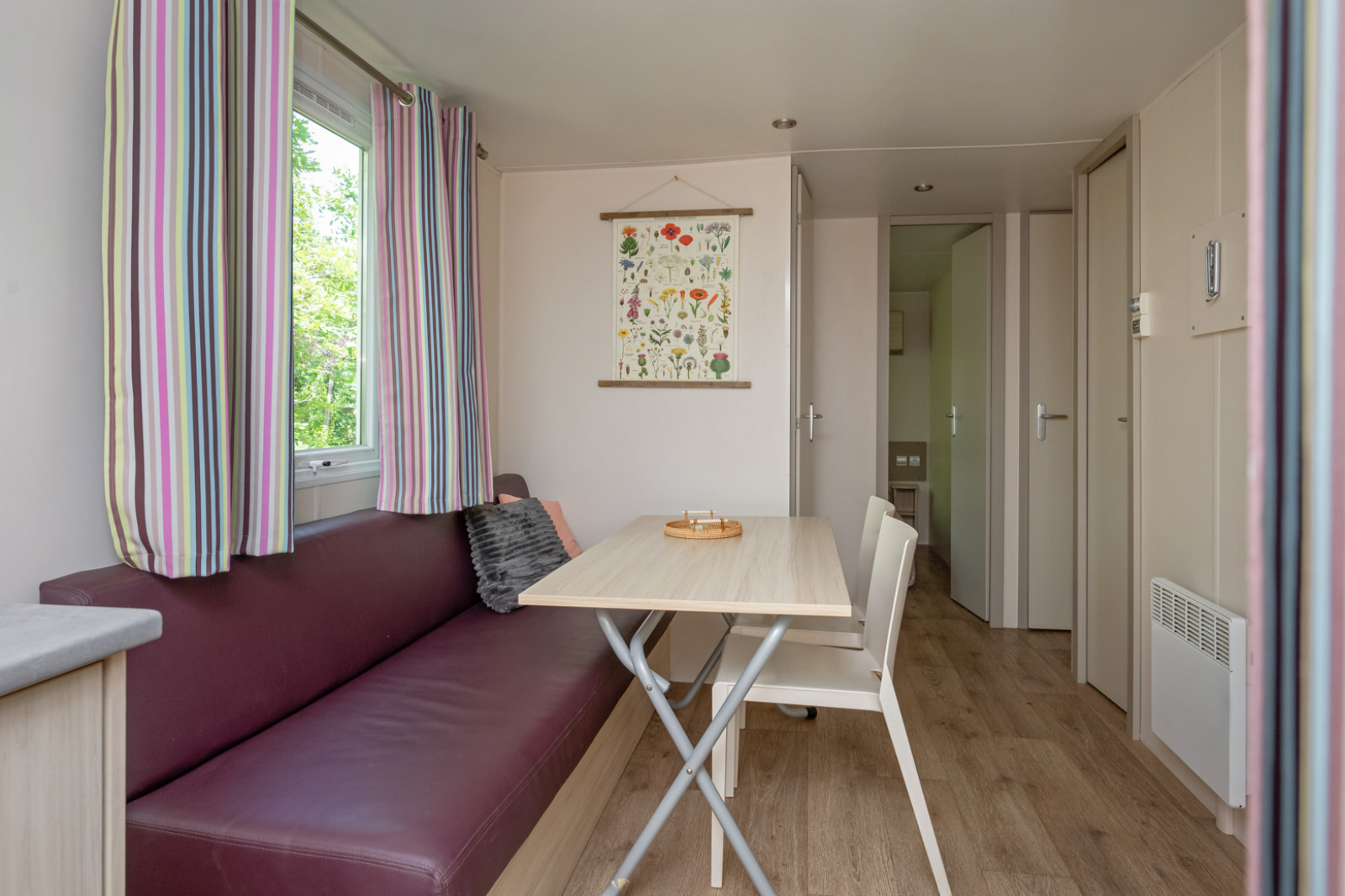 Lichte, knusse woon- en eetruimte in Mobile home «Midi Pyrénées» op Camping Les 3 Cantons, Frankrijk.