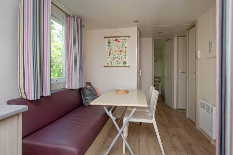 Zona pranzo e soggiorno luminosa e accogliente al Mobile home «Midi Pyrénées» al campeggio Les 3 Cantons, Francia.