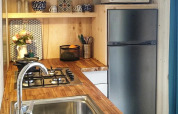 Piccola cucina moderna nel lodge Upupa al campeggio Les 3 Cantons, piano in legno e microonde.