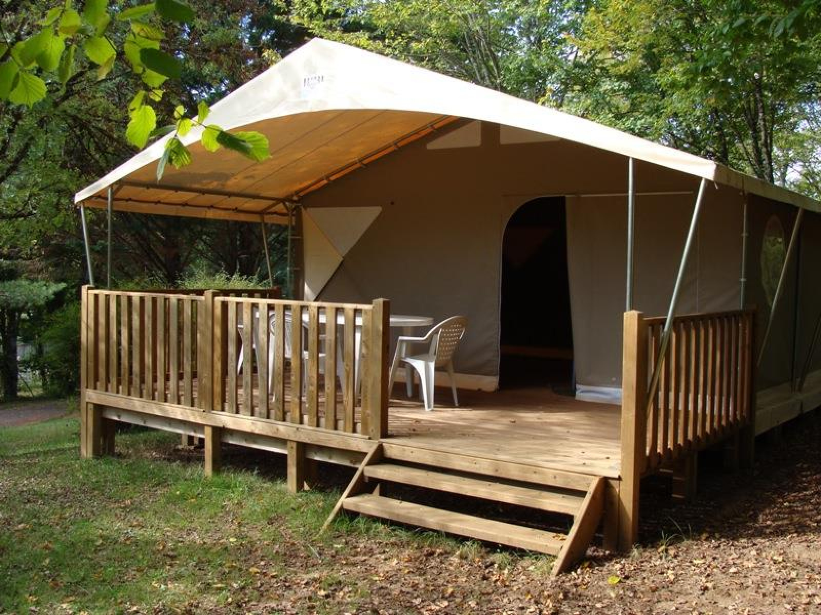 Safari tent Lodge Canada Comfort op Camping La Grande Véyière in Frankrijk, met houten terras en stoelen.