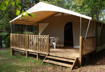 Tenda safari Lodge Canada Comfort al campeggio La Grande Véyière in Francia, con terrazza in legno e sedie.