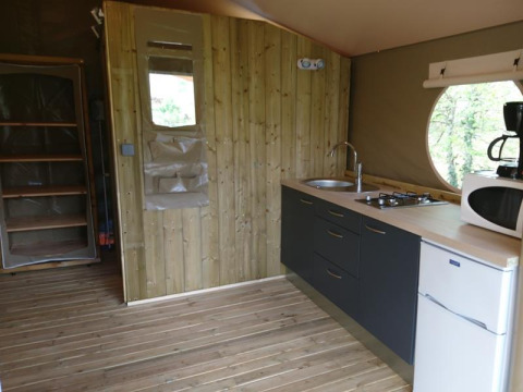 Binnenzicht van de safari tent Lodge «Canada Comfort» met kitchenette op Camping La Grande Véyière, Frankrijk.