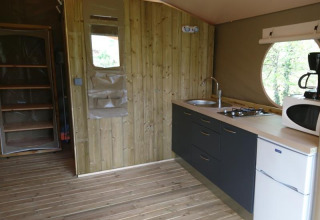 Binnenzicht van de safari tent Lodge «Canada Comfort» met kitchenette op Camping La Grande Véyière, Frankrijk.