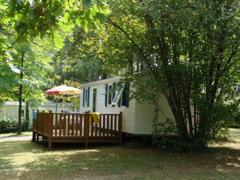 Mobile home Comfort en el camping La Grande Véyière en Francia, rodeado de árboles y vegetación.