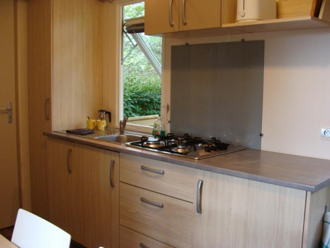Moderne mobilhomekøkken på Comfort ved Campsite La Grande Véyière i Frankrig med komfur og vask.