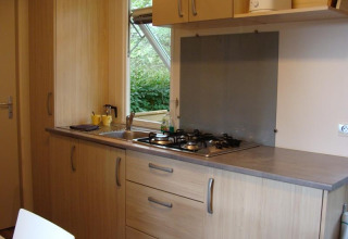 Cuisine moderne de mobil-home Comfort au camping La Grande Véyière en France avec plaque de cuisson.