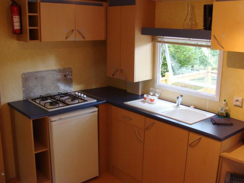 Interno cucina di Mobile home Comfort al Campeggio La Grande Véyière, con fornello a gas e lavello.