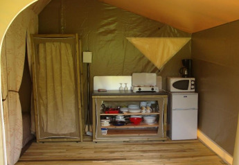 Interno di una tenda safari Lodge «Canada Classic» con angolo cottura al Campeggio La Grande Véyière in Francia.
