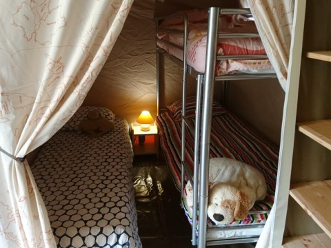Interno di una tenda safari Lodge «Canada Classic» al Campeggio La Grande Véyière in Francia, con letti accoglienti.