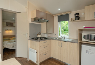 Cocina moderna y dormitorio en una casa móvil Loggia en el camping Les 3 Cantons, Francia.