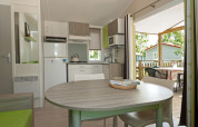 Cuisine et salle à manger modernes dans le mobil-home «Aveyron» avec terrasse au camping Les 3 Cantons.