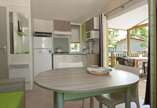 Cuisine et salle à manger modernes dans le mobil-home «Aveyron» avec terrasse au camping Les 3 Cantons.