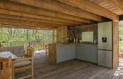 Cucina in casa sull’albero Duiventoren al campeggio Les 3 Cantons, interni in legno e vista sul bosco.